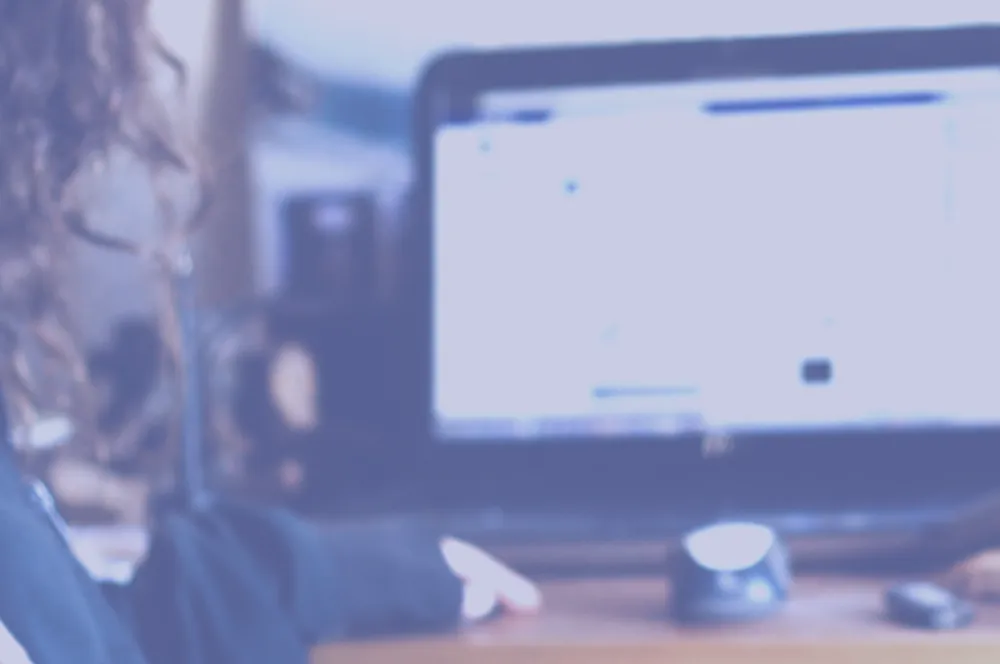 Part of Viviana’s arms and hands are visible in front of a laptop and mouse on a desk.
